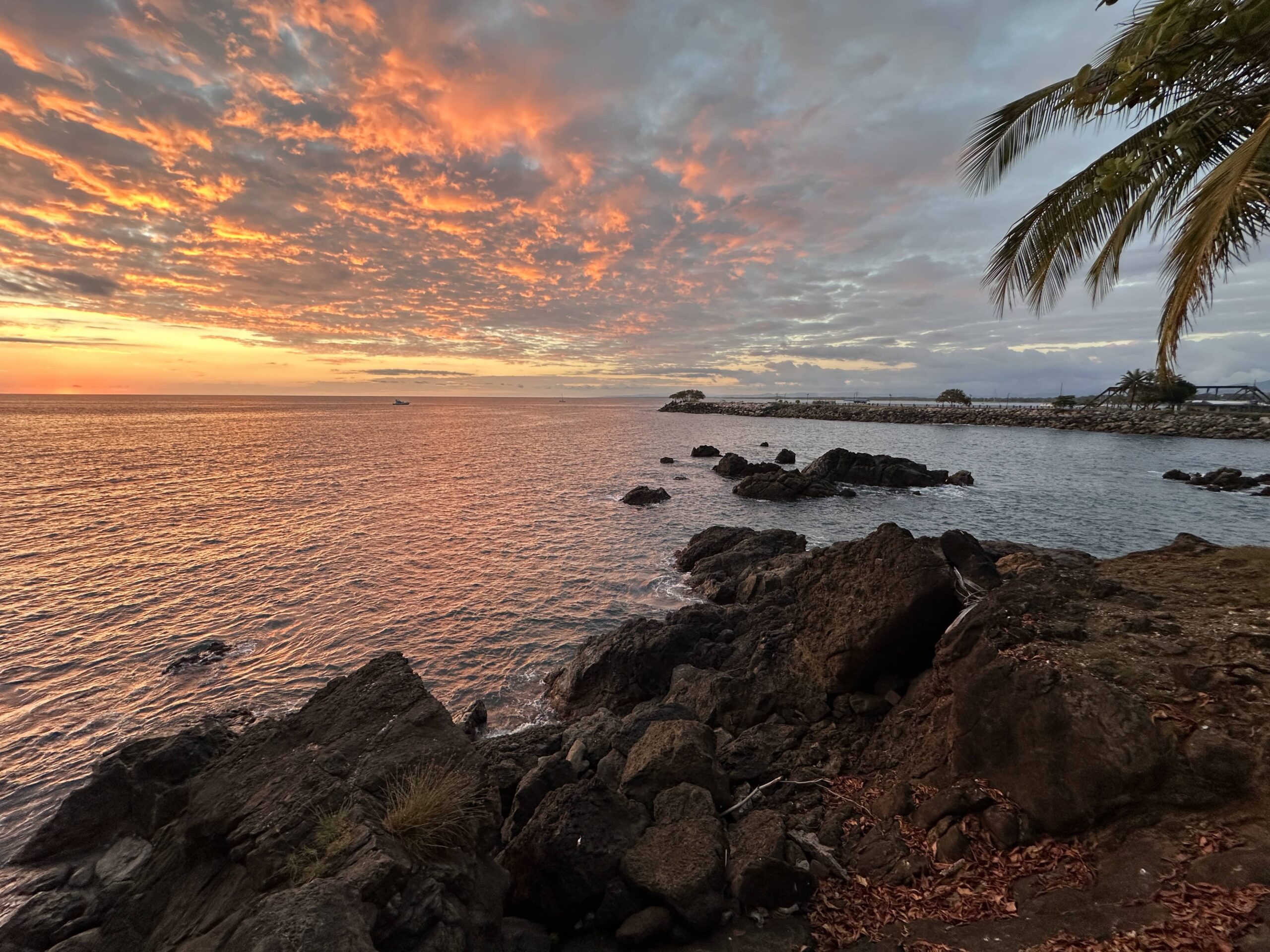 Dramatic tropical sunset with orange and pink clouds over the Pacific Ocean
